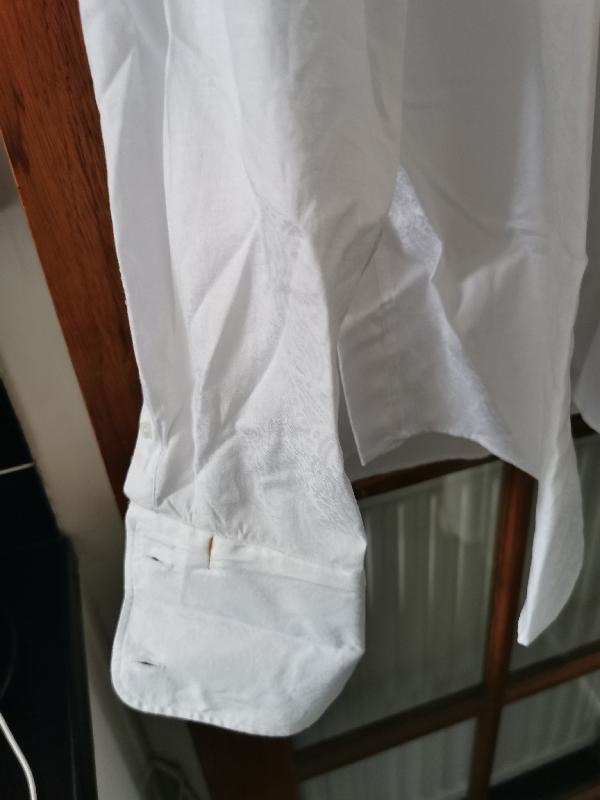 Looked as if shirt had been worn before, stain on inside of cuff. Blood???