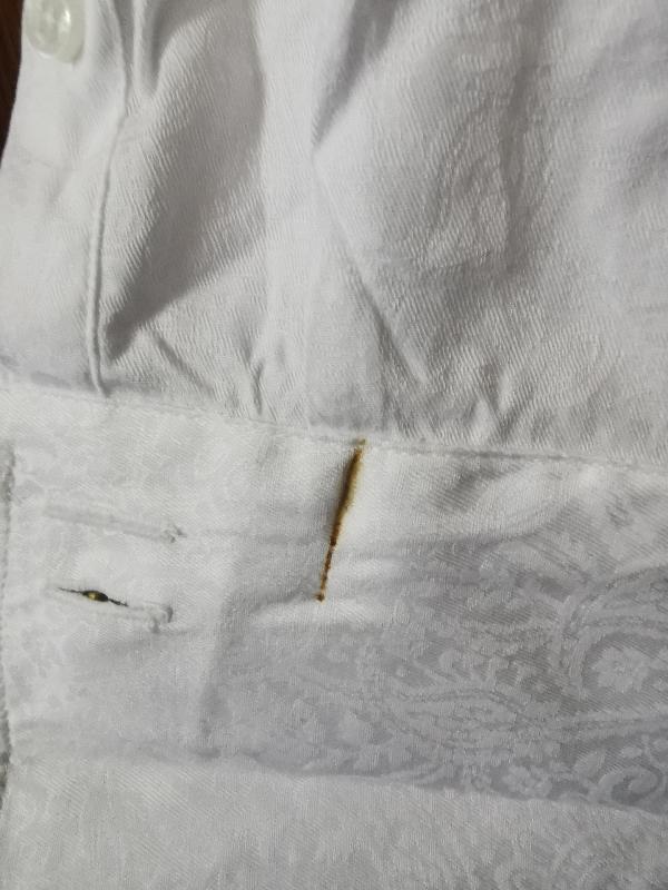 Looked as if shirt had been worn before, stain on inside of cuff. Blood???