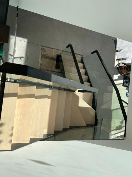 3 storey Carbon staircase with embedded glass balustrade.